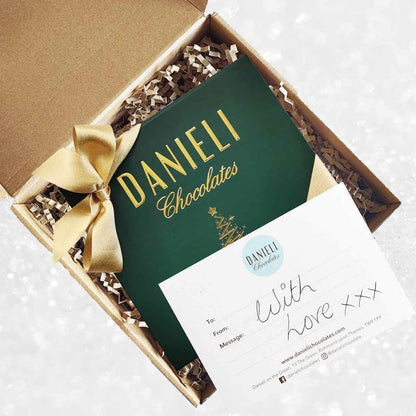 delivery box view of Danieli chocolates for Christmas luxury green box with a gold ribbon on a snowy background