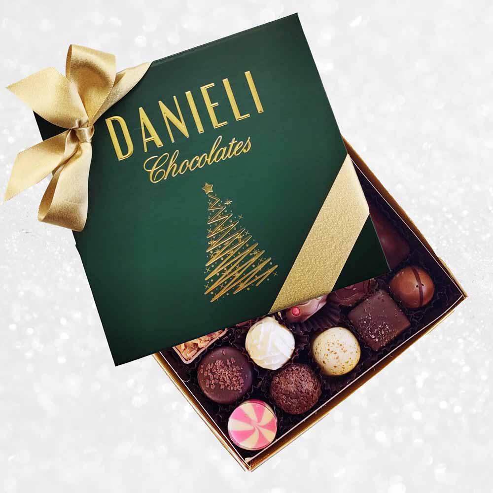 top view of Danieli chocolates for Christmas luxury green box with a gold ribbon on a snowy background