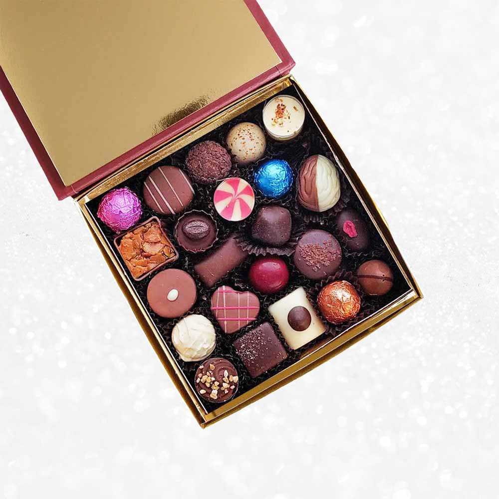 inside view of Danieli chocolates for Christmas luxury red box with a gold ribbon on a snowy background