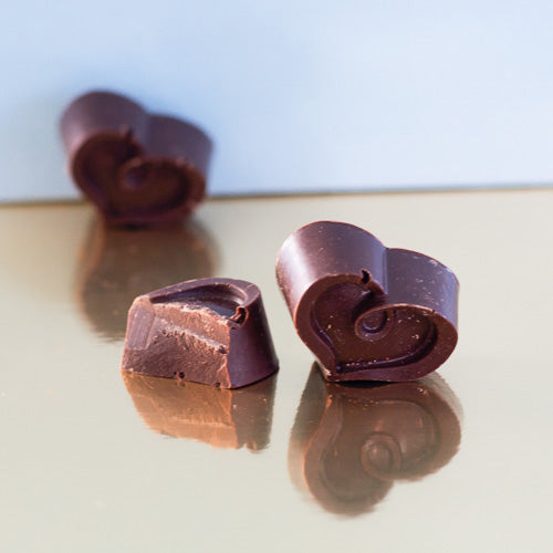 Dark chocolate solid heart on a gold background