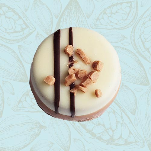 Danieli individual chocolate white chocolate caramel fudge on a blue and brown cacao pod background