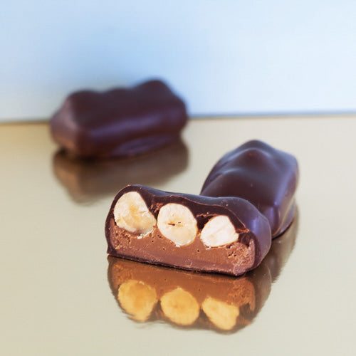 Dark chocolate hazelnut praline trio on a dark background
