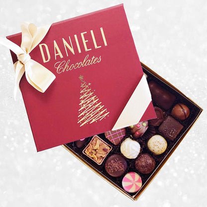 top view of Danieli chocolates for Christmas luxury red box with a gold ribbon on a snowy background